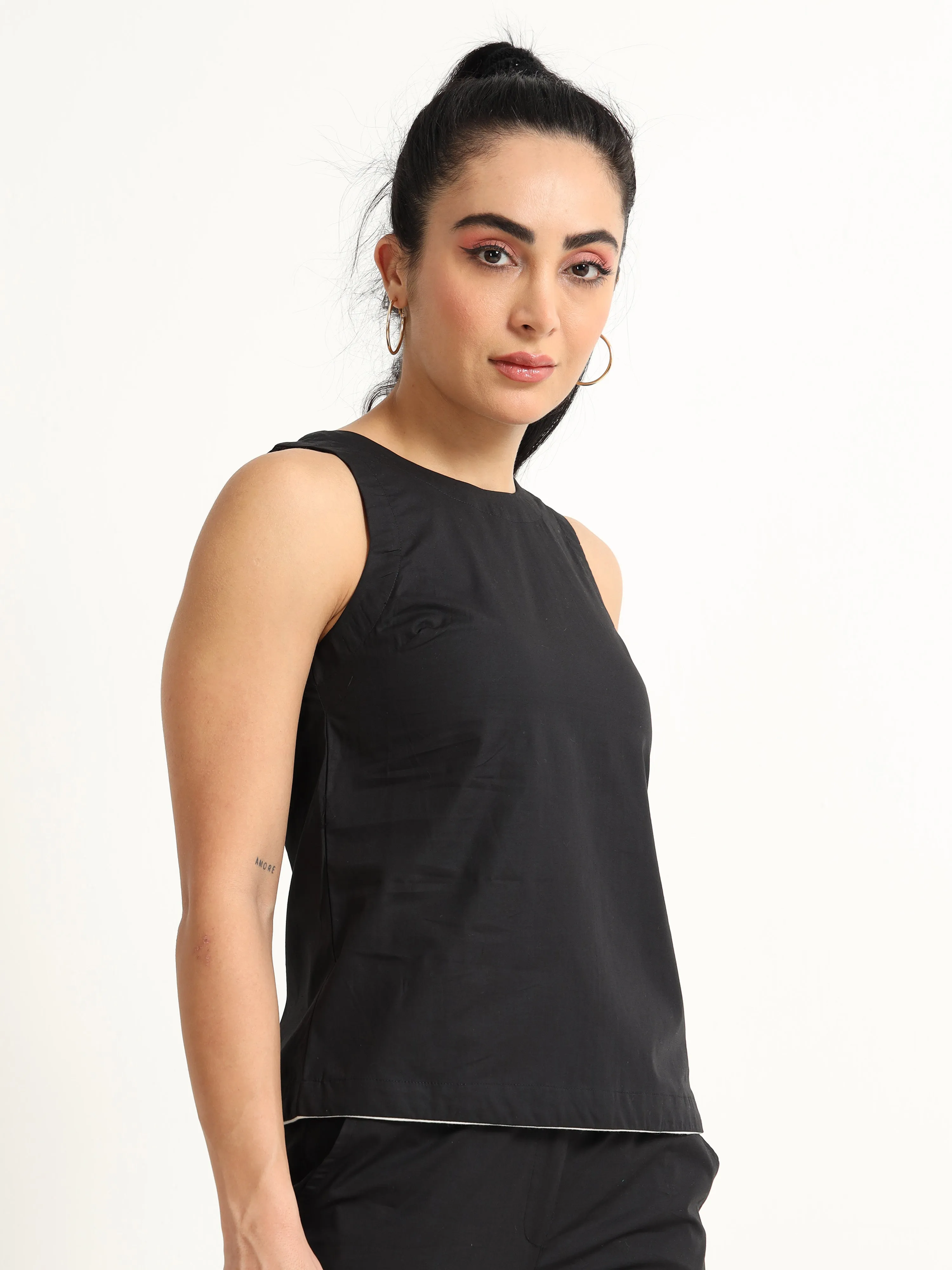 Organic Black cotton Closed neck sleeveless top with white piping detailing at the hem line.