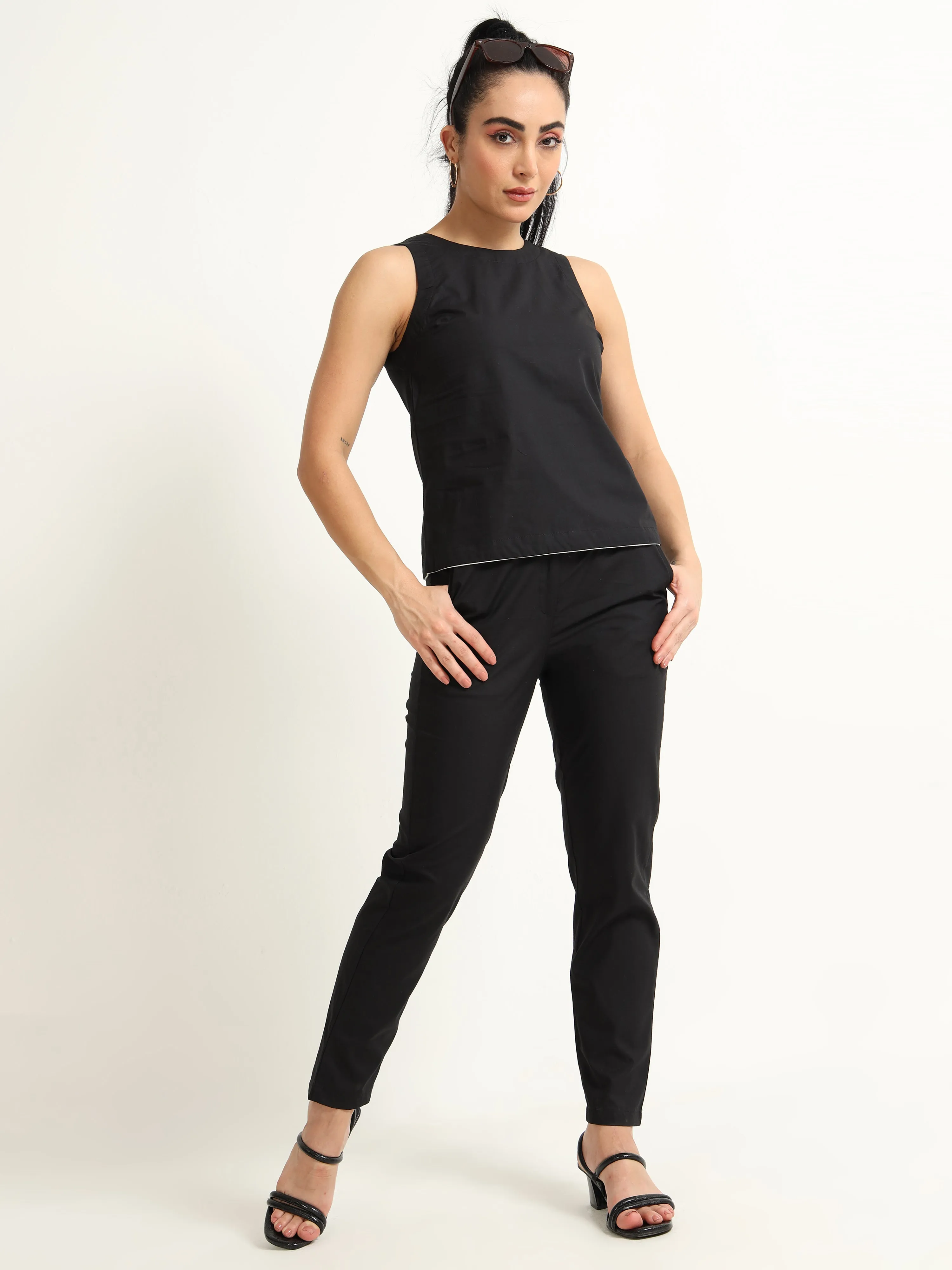 Organic Black cotton Closed neck sleeveless top with white piping detailing at the hem line.