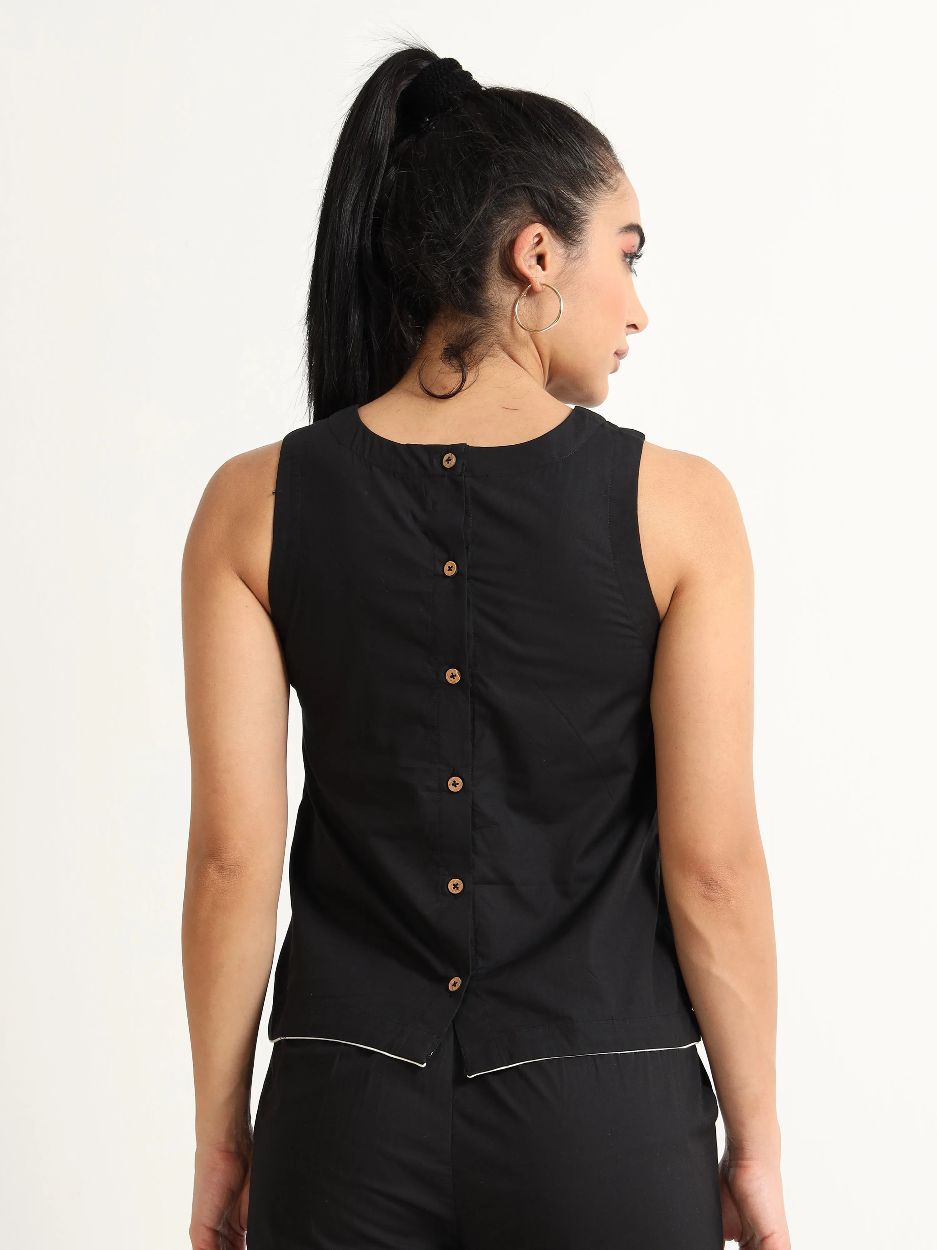 Organic Black cotton Closed neck sleeveless top with white piping detailing at the hem line.