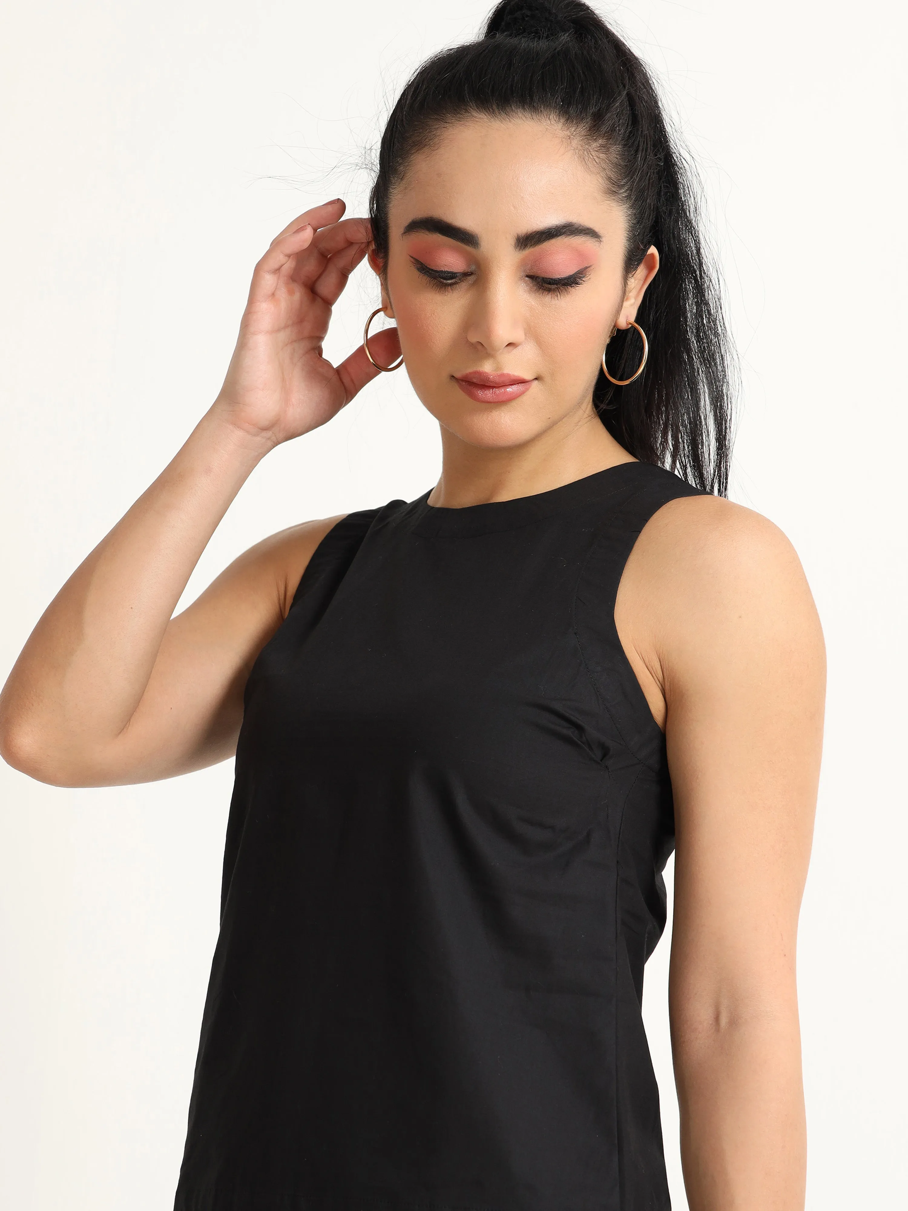 Organic Black cotton Closed neck sleeveless top with white piping detailing at the hem line.